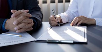 Two people reviewing a contract.