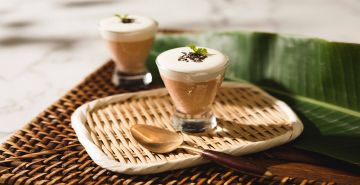 Latte with a spoon on a woven placemat