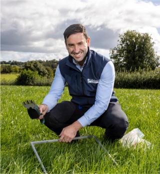 A Lakeland Dairies team member measuring grass in a field belonging to a milk supplier.
