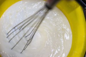 A bucket of milk replacement being mixed.