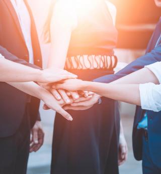 A team members putting their hands in.