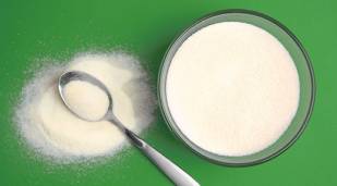 Skimmed milk powder in bowl and spoon