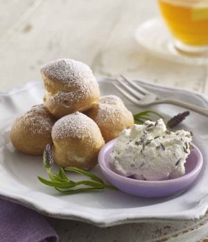 Choux pastry profiteroles with a dish of whipped Lakeland Dairies Whipping Cream with fresh lavender flowers