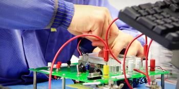 Man in purple shirt connecting wires.