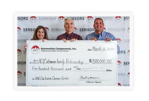 3 people holding a check