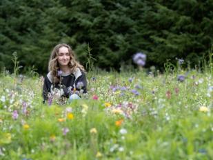 A woman sitting in a field of flowers.