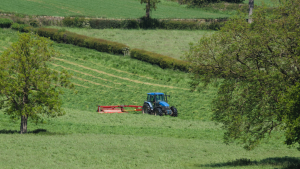 A tractor cutting a field of grass.