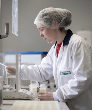 A Lakeland Dairies employee running quality tests on milk.