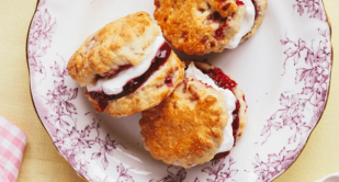 Three scones on a plate, with Lakeland Dairies Real Dairy Whipping Cream and jam inside